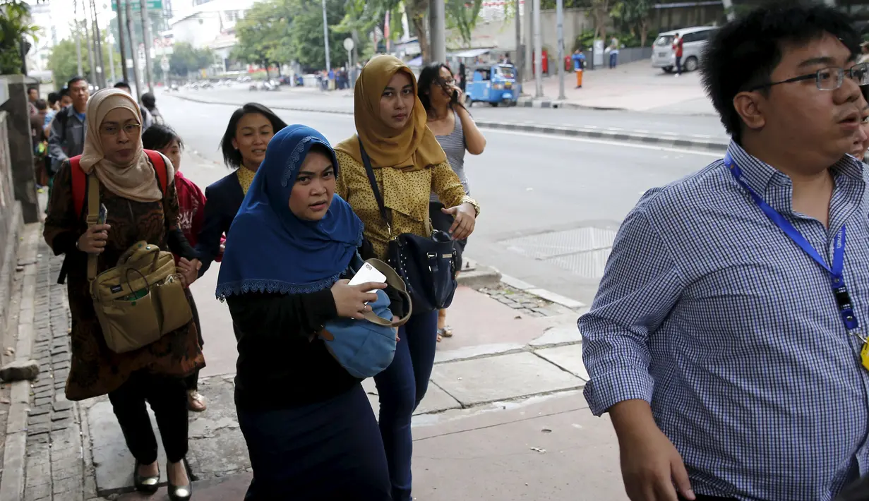 Sejumlah pekerja saat dievakuasi dari kantor mereka di kawasan bisnis Thamrin di Jakarta (14/1/2015). Beberapa ledakan dan suara senjata api terjadi di pusat ibukota Indonesia, Polisi mencurigai seorang melakukan aksi bom bunuh diri. (REUTERS/Beawiharta)