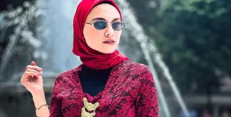 Zee Zee Shahab memamerkan gayanya pakai kebaya brokat klasik berwarna merah. Padu padan inner hitam, korset jumputan merah, kain batik sebagai rok, dan hijab merah polos menambah kesan keren pada keseluruhan penampilan Zee Zee Shahab di sini. [Foto: Instagram/zeezeeshahab]