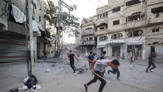 Orang-orang berlari mencari perlindungan setelah serangan Israel yang menargetkan sebuah bangunan di kamp pengungsi Palestina Bureij di Jalur Gaza tengah pada 19 Oktober 2025. (Eyad BABA/AFP)
