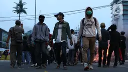 Sekelompok anak muda melintasi kawasan Gondangdia, Jakarta, Kamis (8/10/2020). Massa gabungan berunjuk rasa menentang disahkan Omnibus Law UU Cipta Kerja. (Liputan6.com/Helmi Fithriansyah)