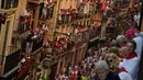 Orang-orang berdiri di balkon saat menunggu dimulainya Festival San Fermin di Pamplona, Spanyol, Senin (9/7). (AP Photo/Alvaro Barrientos)