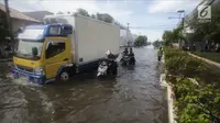 Pengendara mendorong motornya saat melintasi banjir rob di kawasan Muara Baru, Jakarta, Rabu (6/11). Air laut pasang yang terjadi mengakibatkan sejumlah wilayah dilokasi tersebut terendam banjir rob. (Liputan6.com/Faizal Fanani)