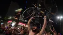 Seorang pria telanjang sambil mengangkat sepedanya saat melakukan aksi di Sao Paulo, Brasil (10/3). Mereka menuntut agar kondisi jalan kota lebih baik, serta meningkatkan kesadaran akan keselamatan pengendara sepeda. (AFP/Nelson Almeida)