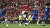 Gelandang Manchester United, Paul Pogba (tengah) menggiring bola dari kawalan pemain Chelsea pada pertandingan Liga Inggris di Old Trafford (11/8/2019). MU menang telak 4-0 atas Chelsea. (AFP Photo/Oli Scarff)