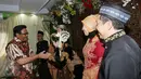 Cawagub DKI Jakarta Djarot Saiful Hidayat memberi ucapan selamat kepada pengantin di Petogogan I, Jakarta Selatan, Minggu (11/12). Djarot berpesan kepada warga untuk menjaga kebersihan dan lingkungan. (Liputan6.com/Fery Pradolo)