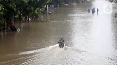 Pengendara memaksa melintasi Jalan Di Panjaitan dekat Halte Transjakarta Cawang Soetoyo, Jakarta, Rabu (1/1/2020). Hujan yang mengguyur Jakarta sejak Selasa sore (31/12/2019) mengakibatkan banjir di sejumlah titik di Jakarta. (Liputan6.com/Helmi Fithriansyah)