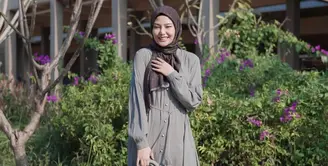 Tampil anggun, Dara Arafah tampak memadukan gamis berwarna abu-abu dengan aksen kancing di bagian depan dengan scarf monogram berwarna coklat. Ia melengkapi penampilannya dengan tas Dior warna senada dengan gamisnya, serta heels berwarna putih. (Instagram/daraarafah).