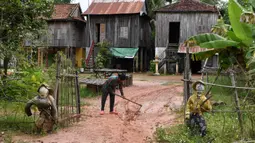 Dua orang-orangan sawah diikat ke pagar depan sebuah rumah di provinsi Kampong Cham, Kamboja, 11 Oktober 2020. Para petani di desa itu menggunakan orang-orangan sawah atau disebut juga Tim Mong untuk menangkal virus corona  Covid-19 berdasarkan kepercayaan yang mereka yakini. (TANG CHHIN Sothy/AFP)