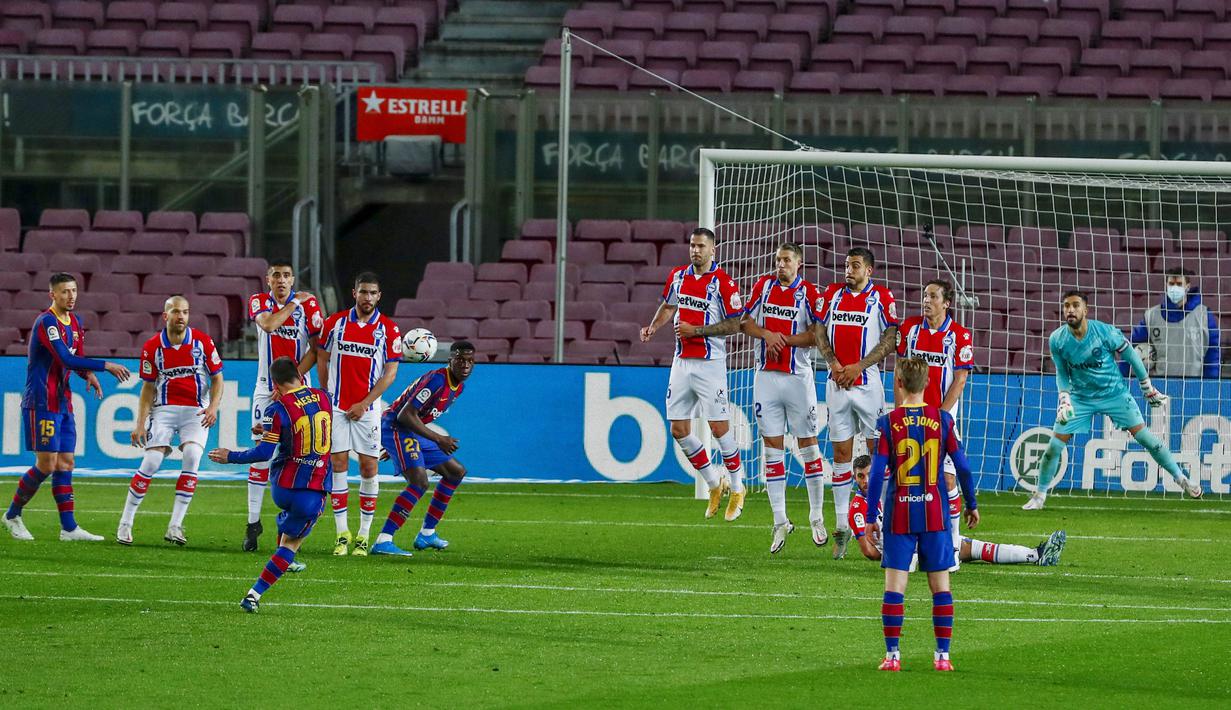 Striker Barcelona, Lionel Messi, melepaskan tendangan bebas saat melawan Alaves pada laga Liga Spanyol di Stadion Camp Nou, Sabtu (14/2/2021). Barcelona menang dengan skor 5-1. (AP Photo/Joan Monfort)