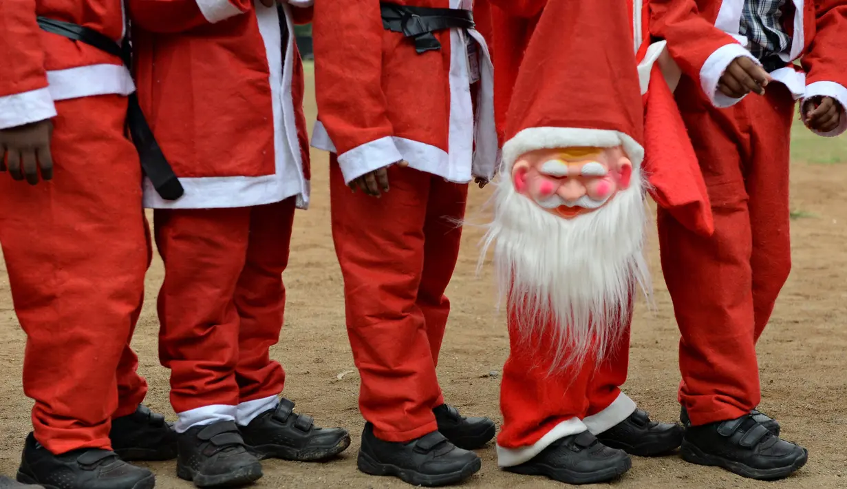 Anak-anak sekolah India berbaris mengenakan kostum Santa Claus dalam acara Natal di sebuah sekolah di Chennai, (5/12). Natal adalah hari raya umat Kristen yang diperingati setiap tanggal 25 Desember. (AFP Photo/Arun Sankar)