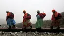 Perempuan suku Aymara saat mendaki Gunung Huayna Potosi, Bolivia (6/4). Perempuan suku Aymara yang berprofesi sebagai tukang masak dan angkut barang atau porter ini selalu mengenakan pakaian tradisional. (REUTERS/David Mercado)