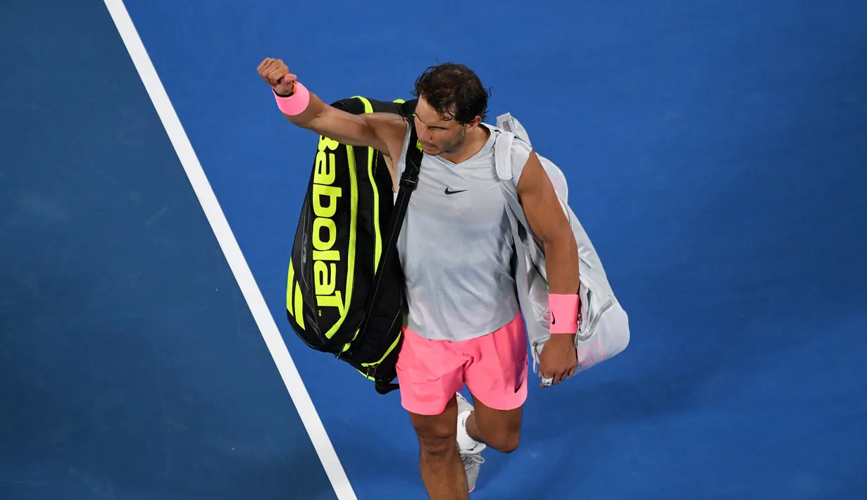 Petenis Spanyol, Rafael Nadal meninggalkan lapangan seusai memutuskan mundur saat melawan petenis Kroasia, Marin Cilic di perempat final Australia Terbuka 2018, Selasa (23/1). Nadal harus tersingkir karena mengalami cedera paha atas. (SAEED KHAN/AFP)