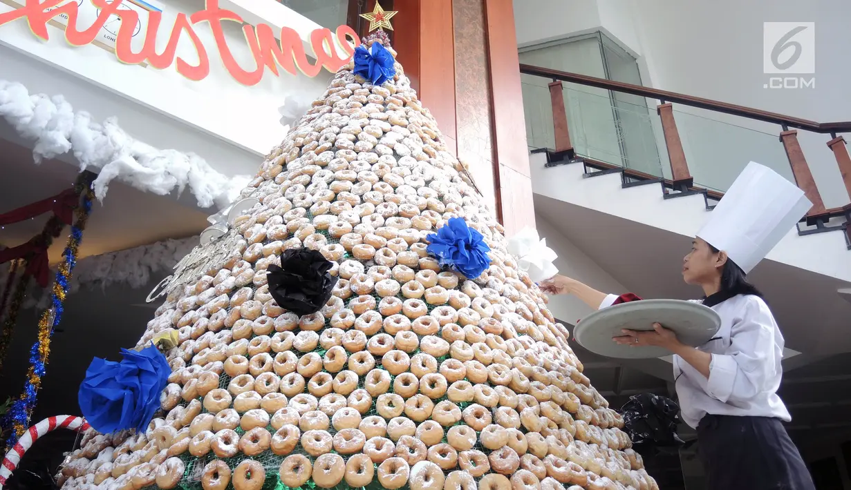 Karyawan menghiasi pohon Natal yang terbuat dari susunan donat di lobby hotel Dafam Semarang, Rabu (12/12). Pohon Natal setinggi 3 meter untuk menyambut Natal tersebut terdapat 2000 buah kue donat. (Liputan6.com/Gholib)