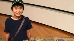 Seorang anak berpose dengan gambar 3D monster pada pameran seni trik 3D karya seniman Jepang Masashi Hattori di Kawasaki, dekat Tokyo, Sabtu, (5/8). (AP Photo / Koji Sasahara)