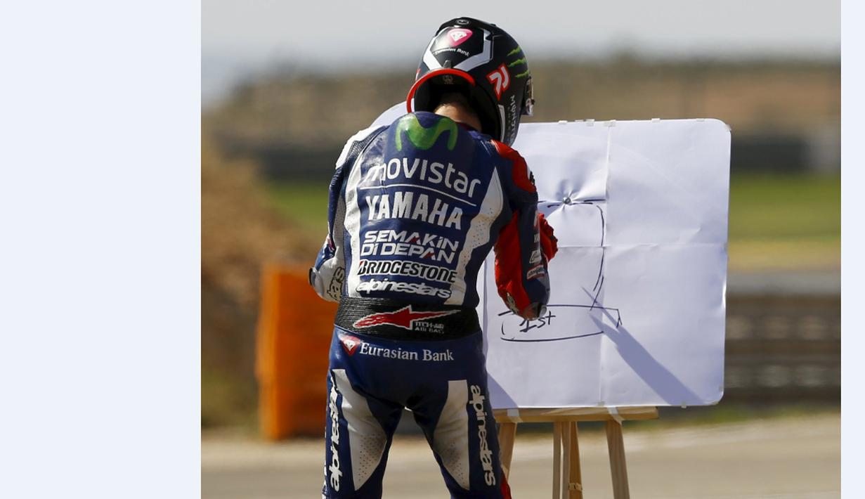 Jorge Lorenzo merayakan kemenangan dengan menulis di papan tulis dalam MotoGP Aragon, Spanyol, Minggu (27/9/2015). (Reuters/Marcelo del Pozo)