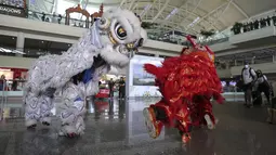 Penari Liong menyambut wisatawan mancanegara (wisman) asal China yang tiba di bandara internasional Ngurah Rai di Bali, Minggu (22/1/2023). China sendiri merupakan salah satu negara pasar terbesar untuk pariwisata di Indonesia.(AP Photo/Firdia Lisnawati)