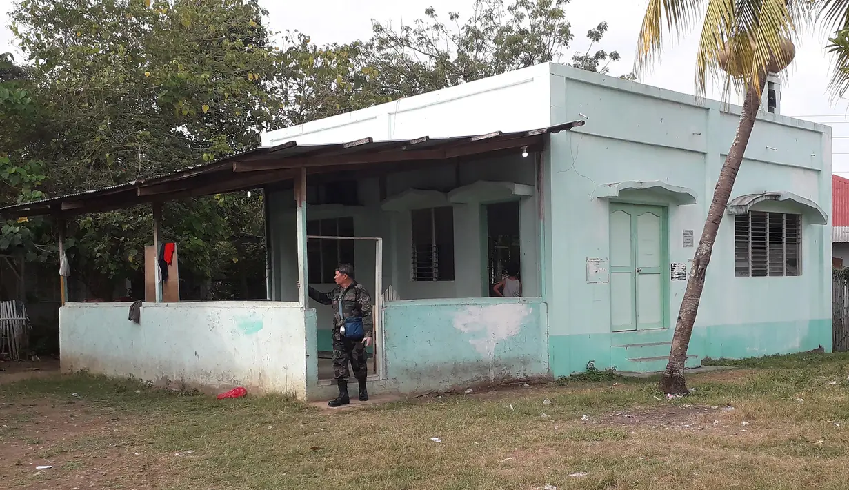 Seorang petugas kepolisian berdiri di pintu masuk sebuah masjid setelah serangan granat di Zamboanga, Filipina selatan, Rabu (30/1). Akibat serangan granat tersebut, dua orang tewas dan empat lainnya luka-luka. (Photo by STR / AFP)