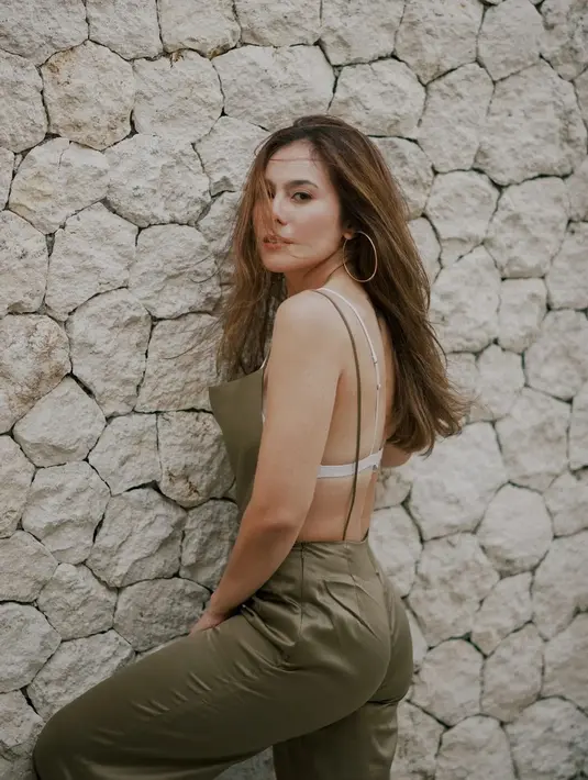 <p>Tidak hanya memamerkan perut ratanya, Wulan Guritno juga pamer punggung dengan outfit pilihannya. Mengenakan backless jumpsuit berwarna olive, Wulan Guritno memadukannya dengan bra tipis berwarna putih. (instagram/wulanguritno)</p>