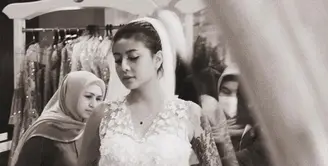 Dalam foto hitam yang diunggah Awkarin, ia memerlihatkan sedang fitting gaun pengantin bersama sang desainer Asky Febrianti. [@narinkovilda]