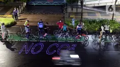 Pegiat bersepeda dan aktivis pecinta lingkungan saat aksi gowes Kelap Kelip Jakarta Night Ride #NOP26 di Kawasan Dukuh Atas, Jalan Jenderal Sudirman, Jakarta, Jumat (26/11/2021). Aksi bertujuan untuk mendorong penggunaan sepeda sebagai solusi transportasi nol emisi. (Liputan6.com/Helmi Fithriansyah)