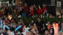 Suporter tim bulutangkis Indonesia bersorak saat menyaksikan siaran langsung laga perempat final dan 16 besar bulutangkis Asian Games 2018 melalui layar lebar di kawasan kompleks GBK, Jakarta, Sabtu (25/8). (Liputan6.com/Helmi Fithriansyah)