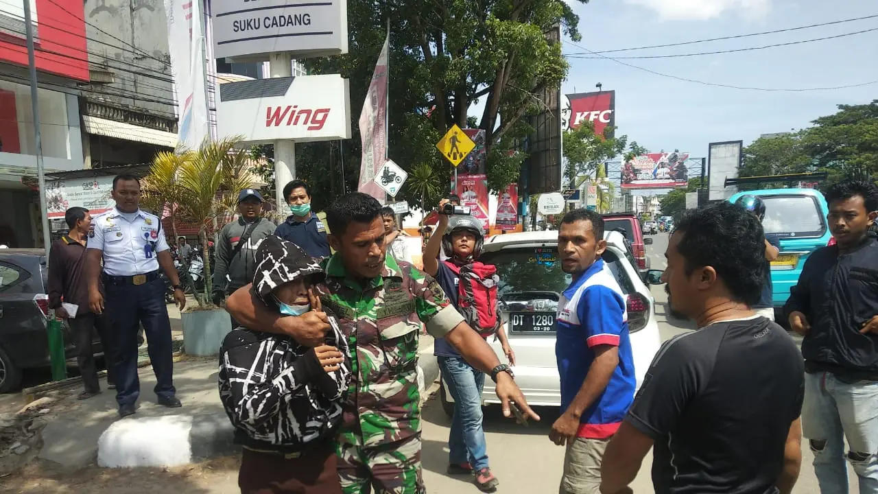 Seorang pria berseragam anggota TNI, membubarkan kelompok tawuran pelajar di Kendari, Jumat (6/12/2019).(Liputan6.com/Ahmad Akbar Fua)