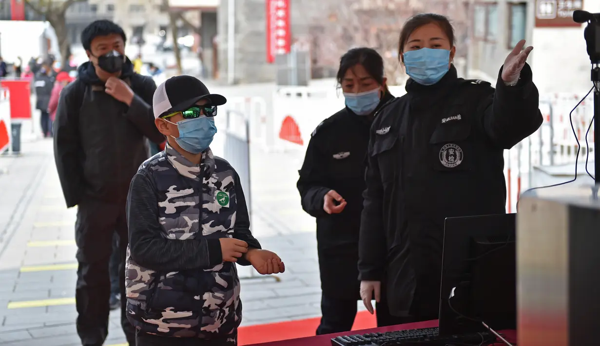 Petugas memeriksa suhu tubuh wisatawan di pintu masuk Tembok Besar bagian Badaling di Beijing, 24 Maret 2020. Bagian dari Tembok Besar yang terkenal di Beijing itu telah dibuka kembali sebagian pada Selasa (24/3), setelah ditutup selama hampir dua bulan akibat corona COVID-19. (Xinhua/Chen Zhonghao)