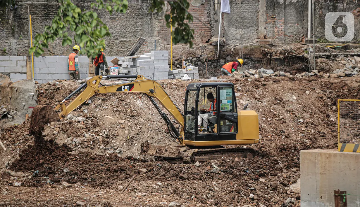 Pekerja menggunakan alat berat untuk menyelesaikan pengerjaan proyek sodetan Ciliwung di Jakarta, Kamis (26/1/2023). Proyek sodetan Ciliwung yang sempat mangkrak enam tahun kembali dilanjutkan. (Liputan6.com/Faizal Fanani)