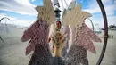 Sandra Mallet melihat karya seni instalasi menyerupai sayap burung di Festival Burning Man, di padang pasir Black Rock, Nevada, Amerika Serikat. (29/08). Karena bersifat eksperimental, festival ini menetapkan sejumlah aturan. (REUTERS/Jim Urquhart)