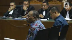 Mantan Kadis PU Papua, Mikael Kambuaya (kiri) dan Komisaris PT MBM, David Manibui saat sidang dakwaan di Pengadilan Tipikor Jakarta, Rabu (20/11/2019). Keduanya didakwa merugikan negara sekitar Rp40,93 miliar dalam pekerjaan peningkatan jalan Kemiri-Depapre TA 2015. (Liputan6.com/Helmi Fithriansyah)