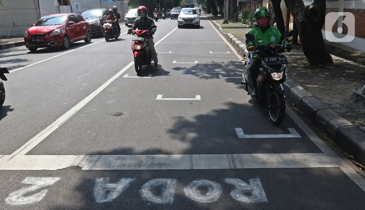 Pengendara motor berhenti pada garis pembatas antarpengendara di kawasan Hang Tuah Raya, Jakarta, Selasa (16/6/2020). Garis tersebut dibuat untuk membatasi jarak antarpengendara guna mencegah penyebaran virus corona COVID-19. (Liputan6.com/Herman Zakharia)