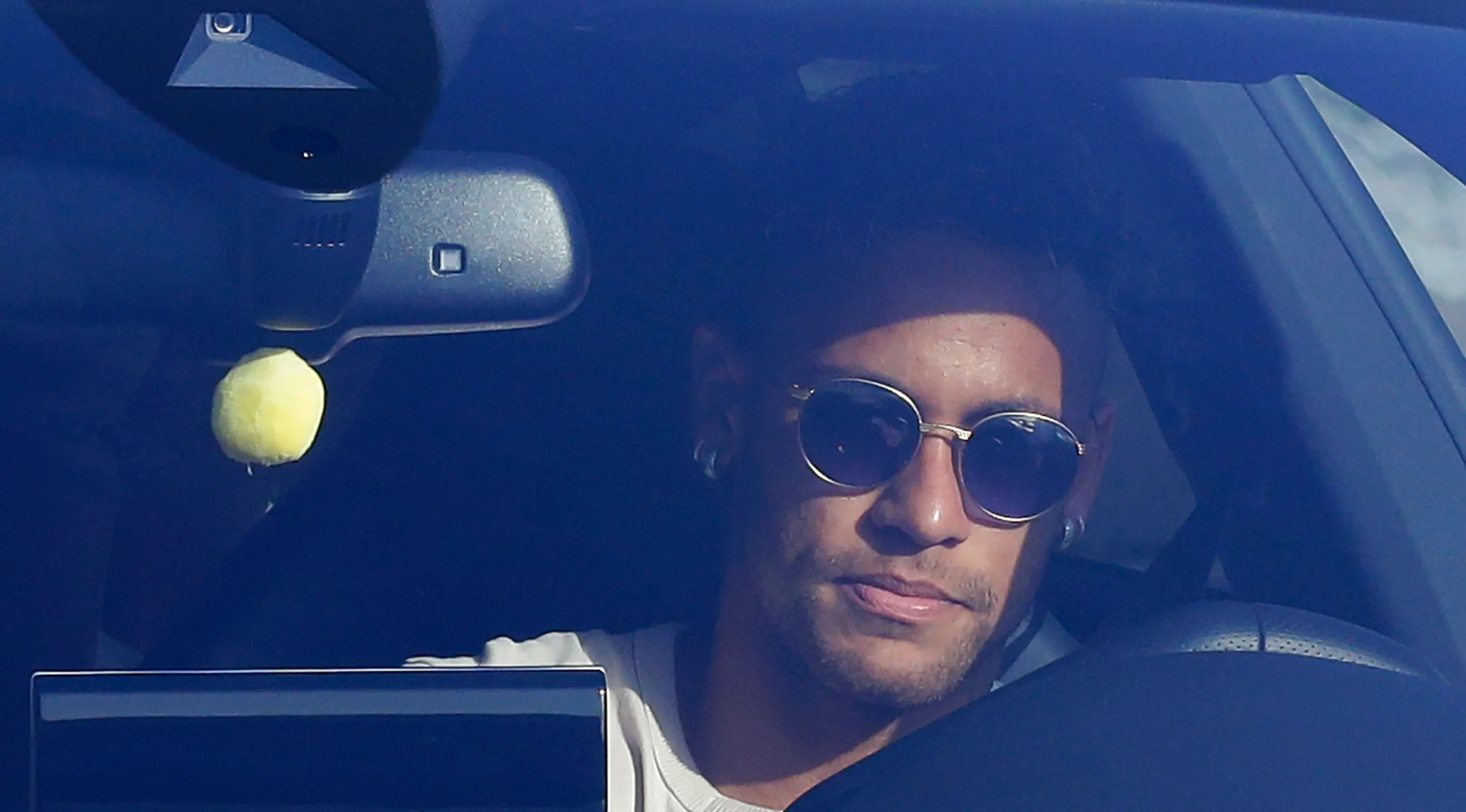Striker Barcelona, Neymar Jr saat berada di dalam mobil saat tiba untuk mengikuti sesi latihan di Pusat Olahraga FC Barcelona Joan Gamper di Sant Joan Despi, Spanyol, Rabu, (2/8). (AP Photo/Manu Fernandez)