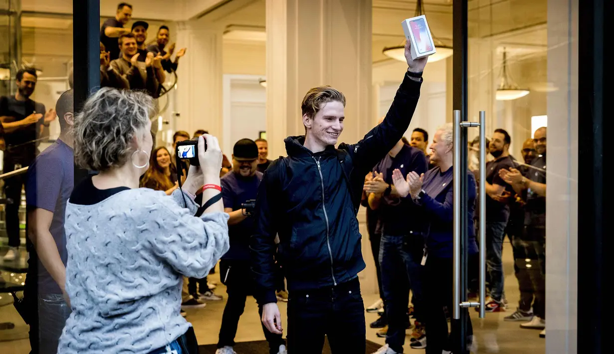 Seorang pria menunjukkan iPhone X usai membelinya di luar toko Apple di Amsterdam, Belanda (3/11). (AFP PHOTO / ANP / Koen van Weel / Netherlands OUT)