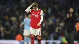 Gelandang Arsenal, Martin Odegaard tertunduk usai pertandingan melawan Manchester City pada putaran keempat Piala FA di Stadion Etihad di Manchester, Inggris, Sabtu (28/1/2023). Kekalahan ini membuat Arsenal gagal lolos ke putaran kelima Piala FA 2022-2023. (AP Photo/Dave Thompson)