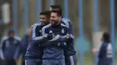 Ever Banega (kiri) memeluk Lionel Messi dan Angel Di Maria pada sesi latihan jelang melawan Venezuela pada kualifikasi Piala Dunia 2018 di Buenos Aires, Argentina, (3/9/2017). (AP/Natacha Pisarenko)