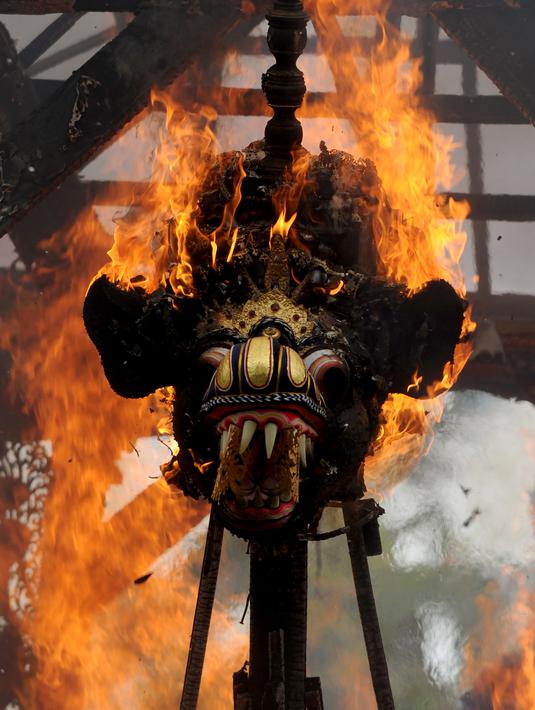 Peti berbentuk naga yang berisi jenazah anggota keluarga dari pahlawan nasional I Gusti Ngurah Rai dibakar dalam prosesi upacara Ngaben di Desa Carangsari, Bali, Senin (29/4/2019). Ribuan waga mengiringi kremasi terhadap jenazah putra kedua dan cucu dari I Gusti Ngurah Rai itu. (SONNY TUMBELAKA/AFP)