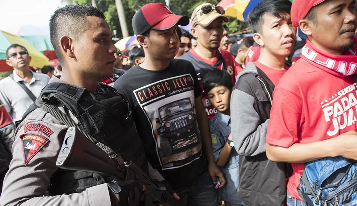 Petugas keamanan bersiaga saat suporter Semen Padang antri memasuki Stadion Utama Gelora Bung Karno, Jakarta, jelang final Piala Jenderal Sudirman antara Semen Padang melawan Mitra Kukar, Minggu (24/1/2016). (Bola.com/Vitalis Yogi Trisna)