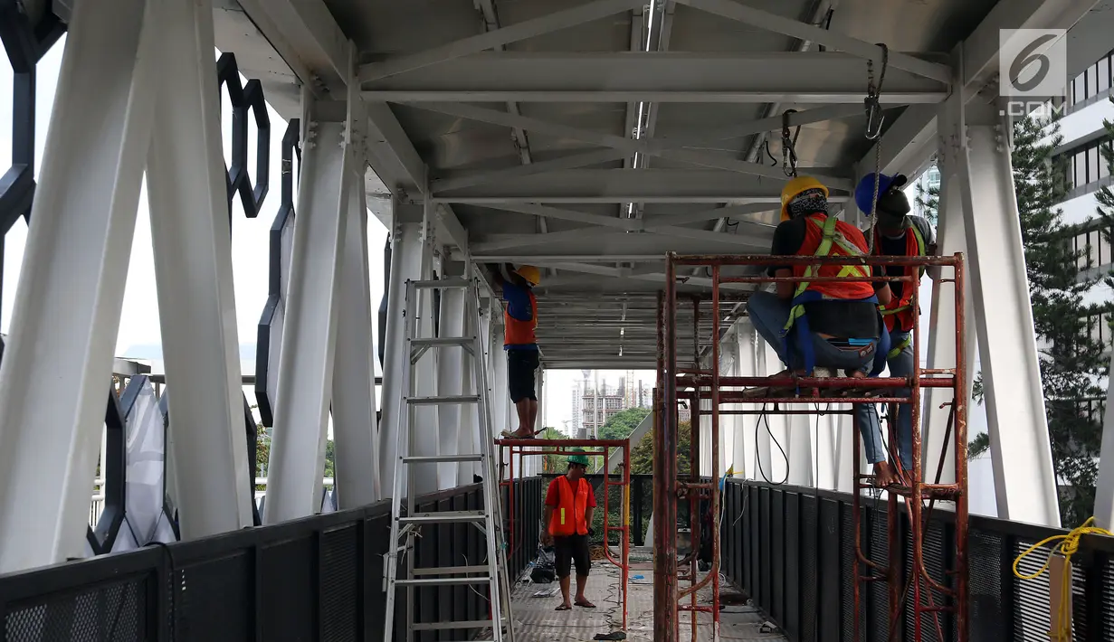 Pekerja menyelesaikan pembangunan JPO di Dukuh Atas, Jakarta, Kamis (20/12). Pembangunan JPO Halte Transjakarta Dukuh Atas sisi Timur dilakukan untuk merelokasi JPO yang posisi tiang (kolom penyangga) berada di tengah ruas jalan. (Liputan6.com/JohanTallo)