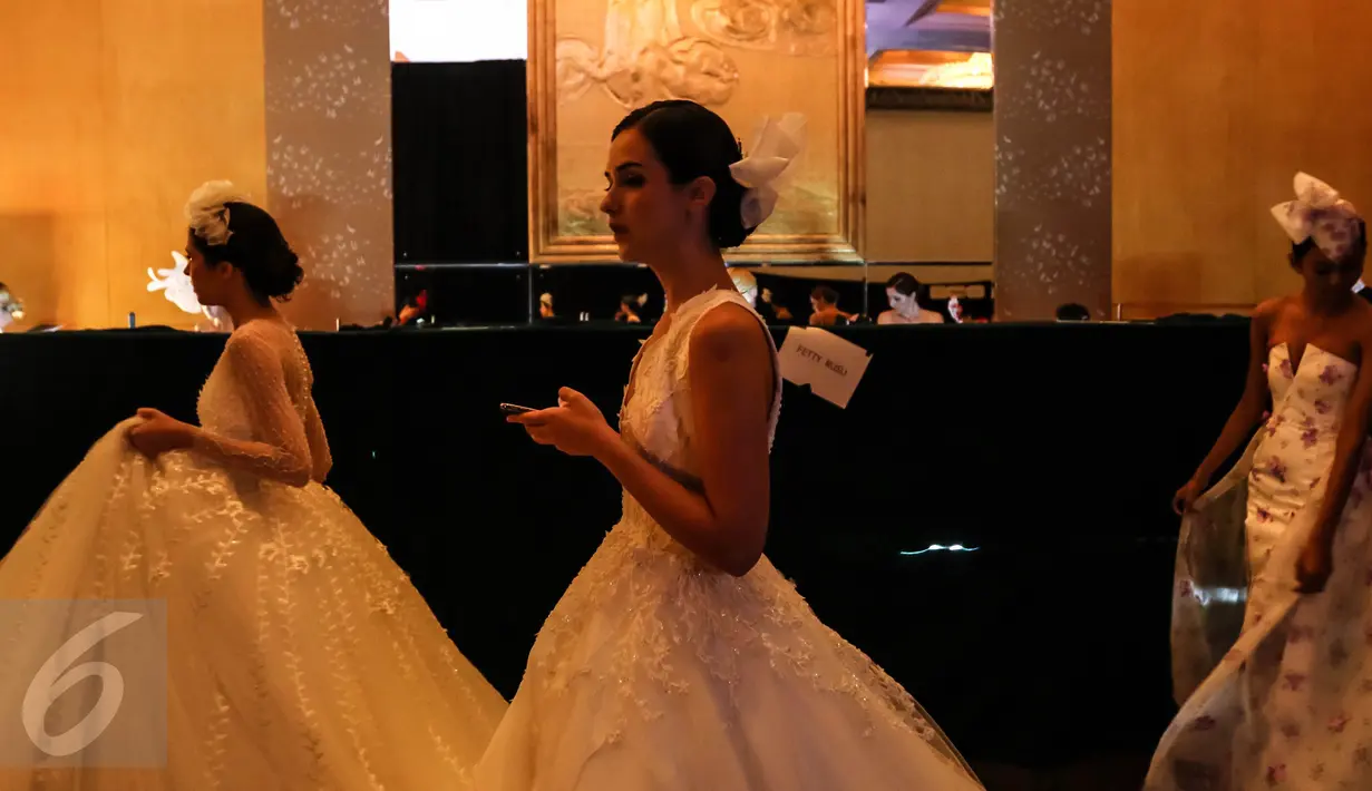 Tiga model berjalan sebelum pagelaran busana karya desainer Fetty Rusli di Hotel Mulia Senayan Jumat (26/02). Busana pengantin menambah detail dedaunan yang menyatu dengan indah. (Liputan6.com/Fery Pradolo)