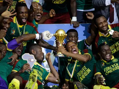 Pemain Kamerun mengangkat piala saat merayakan kemenangan atas Mesir pada laga final Piala Afrika 2017 di Stade de I'Amitie, Gabon, Minggu (5/2). Kamerun meraih gelar kelima Piala Afrika seusai menang 2-1 atas Mesir. (AP Photo/Sunday Alamba)