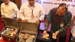 Direktur Departeman Pengelolaan Uang Bank Indonesia Yudi Harymukti (kanan) memusnahkan uang palsu di gedung Bank Indonesia, Jakarta, Rabu (26/2/2020). Bank Indonesia memusnahkan 50.087 lembar uang Rupiah palsu. (Liputan6.com/Angga Yuniar)