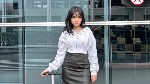 Fuji an memadukan midi skirt leather hitam dengan jaket crop top warna putih dan sneakersnya. [@fuji_an]