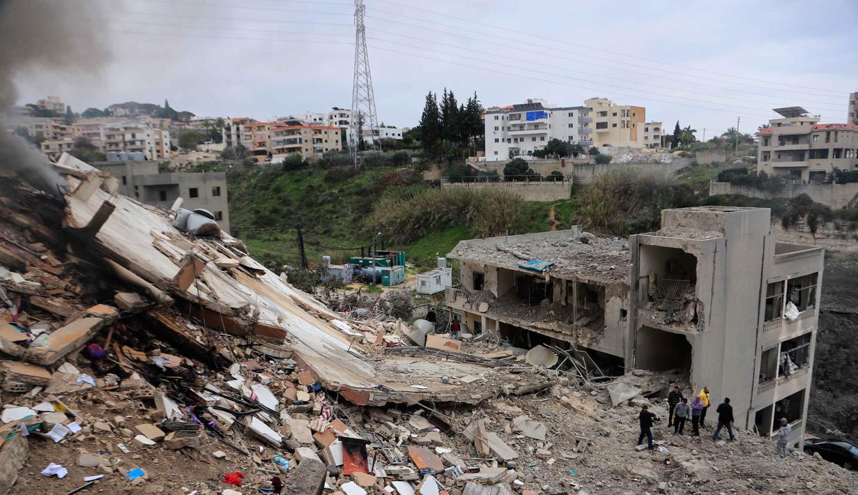 Serangan yang menghantam desa-desa seperti Qennarit memicu peringatan evakuasi massal bagi warga setempat. Tampak dalam foto, warga memeriksa bangunan-bangunan yang hancur akibat serangan Israel di desa Qennarit, Lebanon selatan, Kamis 22 Januari 2026. (AP Photo/Mohammed Zaatari)
