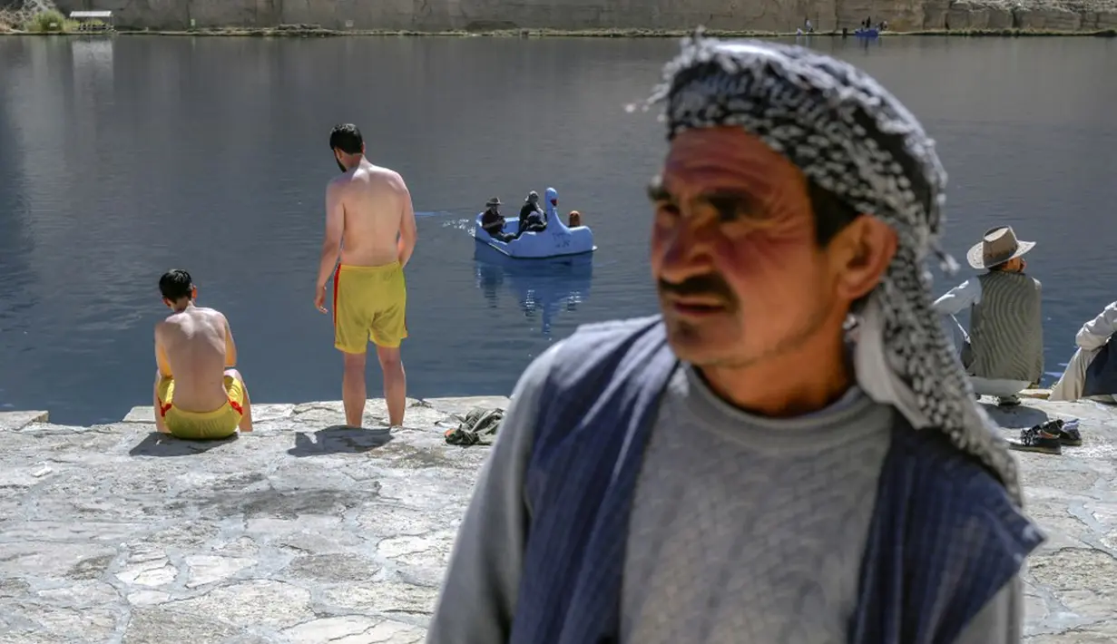 Wisatawan menikmati hari mereka di Danau Band e-Amir, Provinsi Bamiyan, 4 Oktober 2021. Danau Band-e Amir yang memiliki perairan biru menakjubkan disebut juga sebagai Grand Canyon Afghanistan. (BULENT KILIC/AFP)