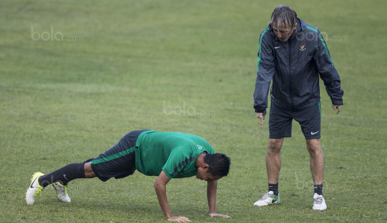 Gelandang Timnas Indonesia, Evan Dimas, diminta pelatih fisik, Miguel Gandia, untuk push up usai latihan di Stadion UKM, Selangor, Sabtu (19/8/2017). Evan kalah saat bermain crossbar dengan Miguel. (Bola.com/Vitalis Yogi Trisna)