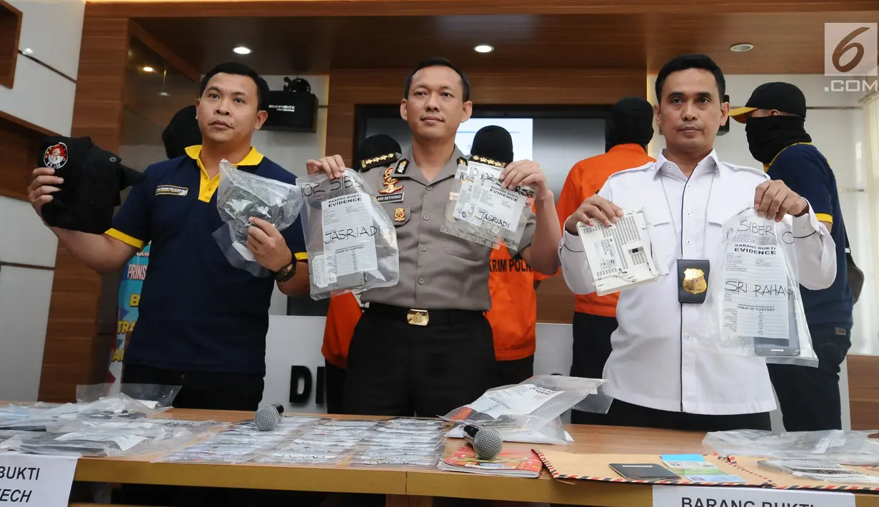 Kasubbagops Satgas Patroli Siber, AKBP Susatyo Purnomo (kiri) menunjukkan barang bukti kasus penyebaran ujaran bernada kebencian lewat internet saat rilis di Mabes Polri Jakarta, Rabu (23/8). Tiga tersangka ditangkap. (Liputan6.com/Helmi Fithriansyah)