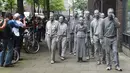Sejumlah orang melakukan demontasi bertajuk aksi "1000 Gestalten" di Hamburg, Jerman, Rabu (5/7). Demonstran melumuri tubuh mereka dengan tanah liat. (AFP PHOTO / Christof Stache)