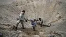 Pencari ranjau dari Kementerian Dalam Negeri Ukraina menyiapkan bahan peledak pada sebuah lubang untuk meledakkannya dekat ladang ranjau setelah pertempuran baru-baru ini di Desa Moshchun, dekat Kiev, Ukraina, 19 April 2022. (AP Photo/Efrem Lukatsky)