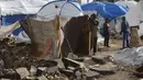 Dan kini tenda-tenda tersebut terpapar langsung massa udara kutub yang membawa suhu dingin ekstrem. Tampak dalam foto, seorang pria Palestina yang mengungsi memperbaiki tenda yang didirikan di sepanjang pantai Kota Gaza saat angin musim dingin yang kencang menerpa wilayah tersebut pada Selasa 13 Januari 2026. (Omar AL-QATTAA/AFP)