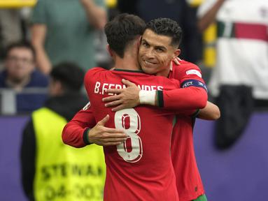 Timnas Portugal memastikan langkahnya melaju ke babak 16 besar Euro 2024 setelah mencatat kemenangan keduanya di Grup F dengan membungkam Turki 3-0 di Westfalenstadion, Dortmund, Jerman, Sabtu (22/6/2024) malam WIB. Ketiga gol jawara Euro 2016 tersebut di cetak lewat Bernardo Silva (21'), bunuh diri Samet Akaydin (26') dan Bruno Fernandes (56'). Meski tak mencetak gol, sang megabintang Cristiano Ronaldo kembali mencetak assist untuk gol Bruno Fernandes dalam laga tersebut. Hingga rampungnya matchday kedua, Portugal menjadi kontestan ketiga yang memastikan melaju ke babak 16 besar setelah Jerman dan Spanyol. (AP Photo/Darko Vojinovic)